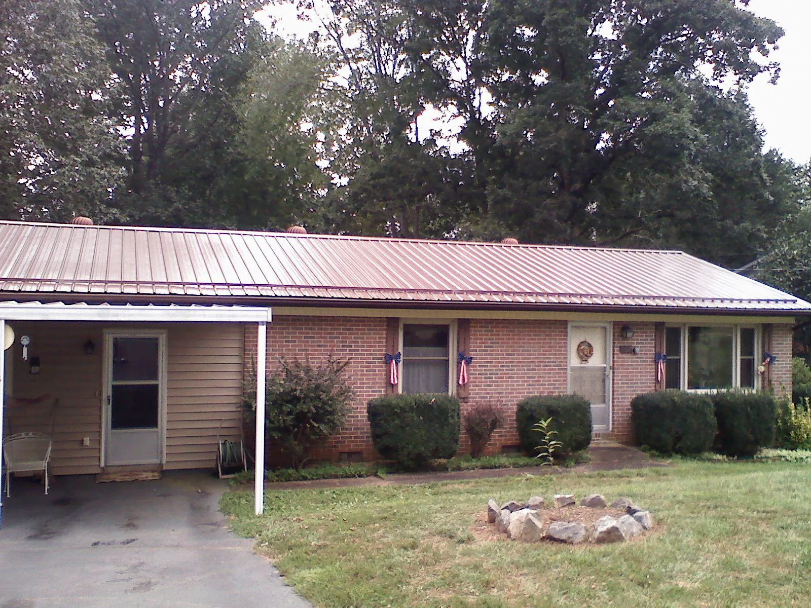 Bronze metal roof and carport on a brick ranch home — Roof Repair work by our crew in Adams